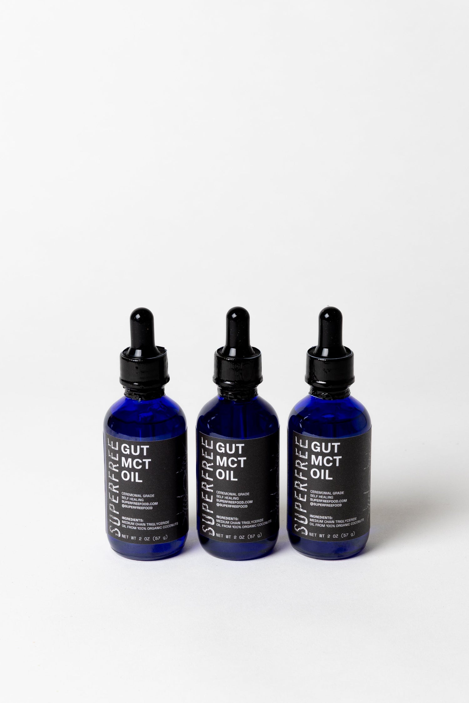 Three bottles of Superfree Gut MCT Oil on a white background