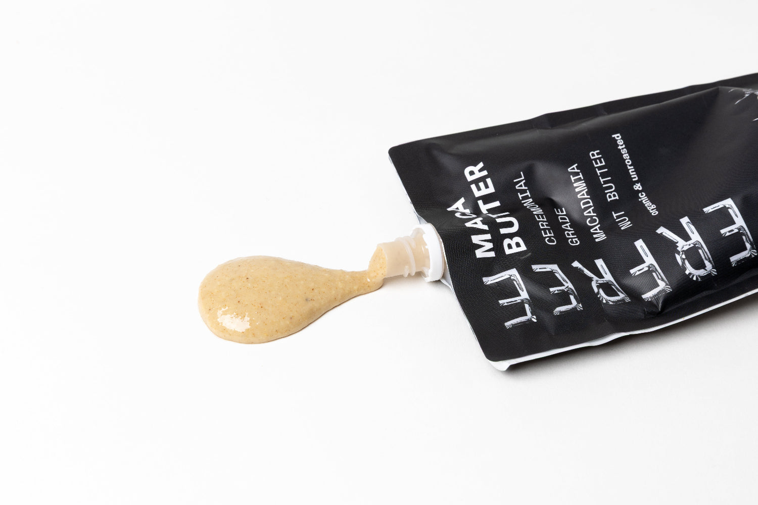 Maca Butter pouch with a squeeze of maca butter coming out on a white background