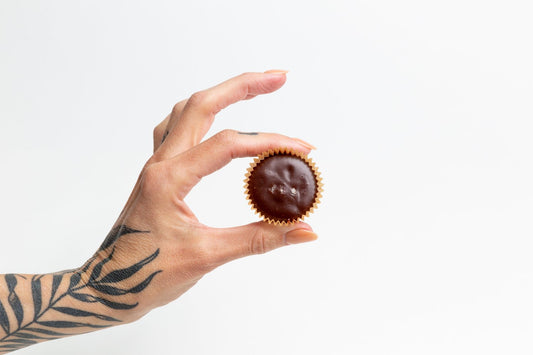 Superfree Raw Cacao Truffle between fingertips